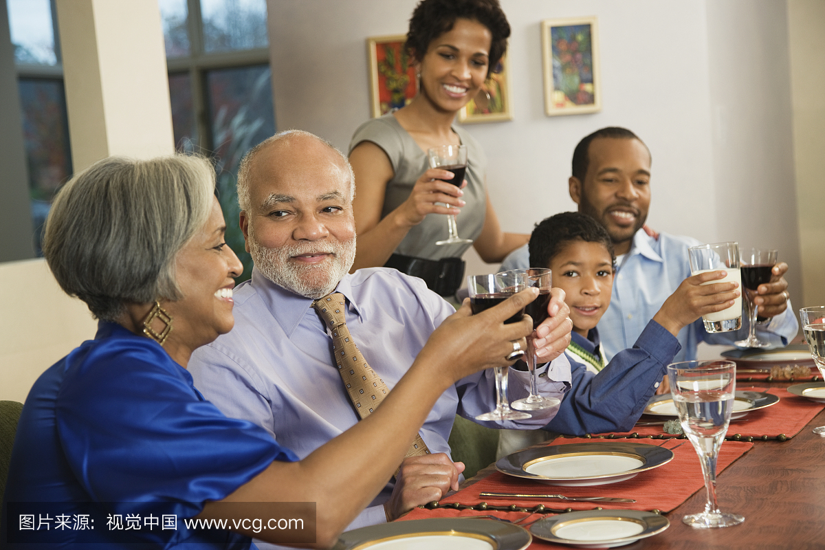 非洲裔美国人家人在餐桌上品尝葡萄酒