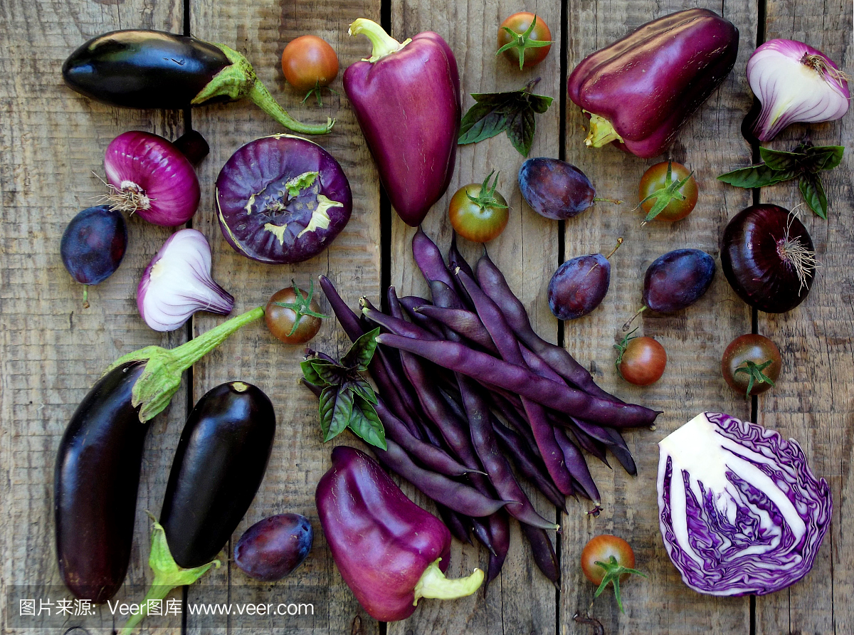 在木背景上的紫色蔬菜和水果