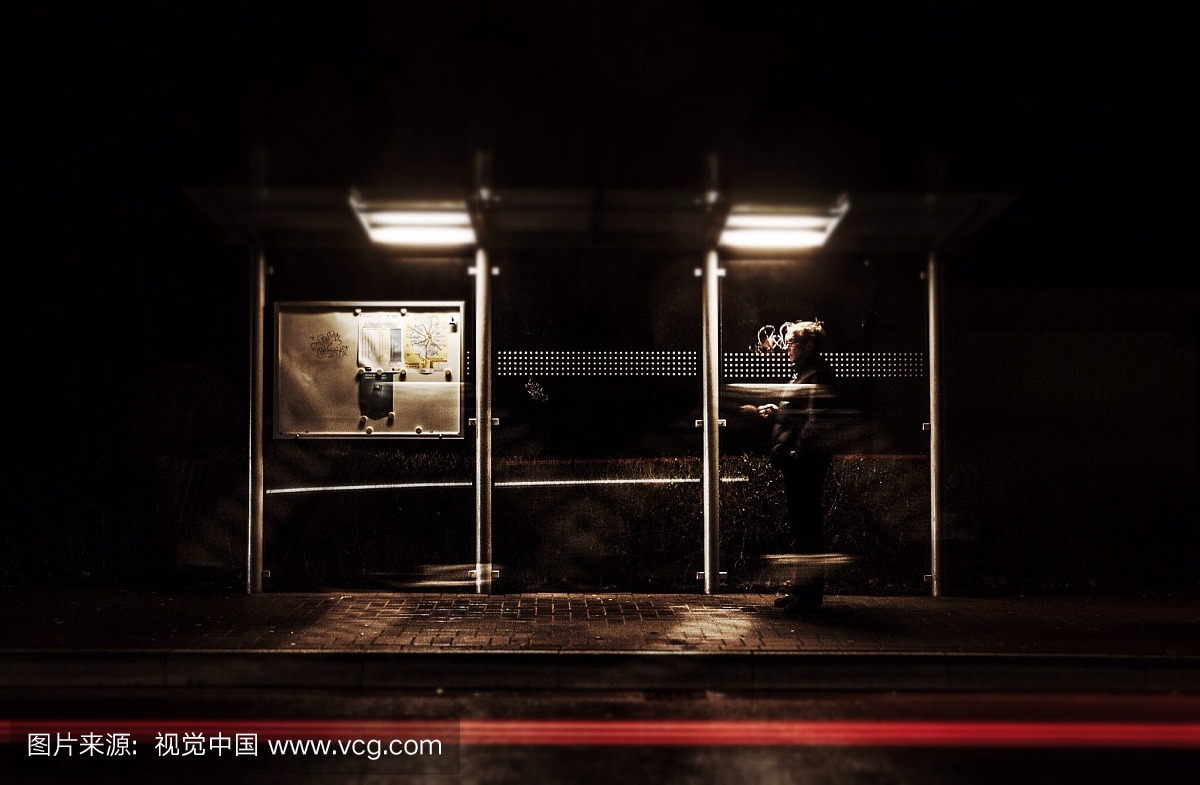 男人在晚上等候公共汽车