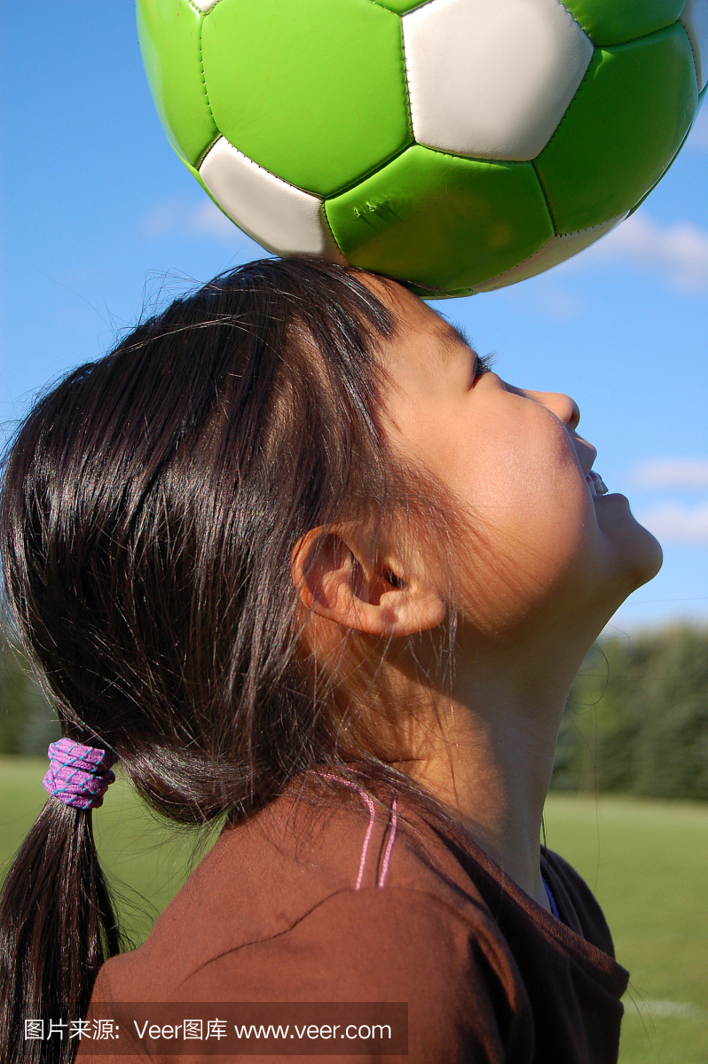 女孩在她的头上有一个足球